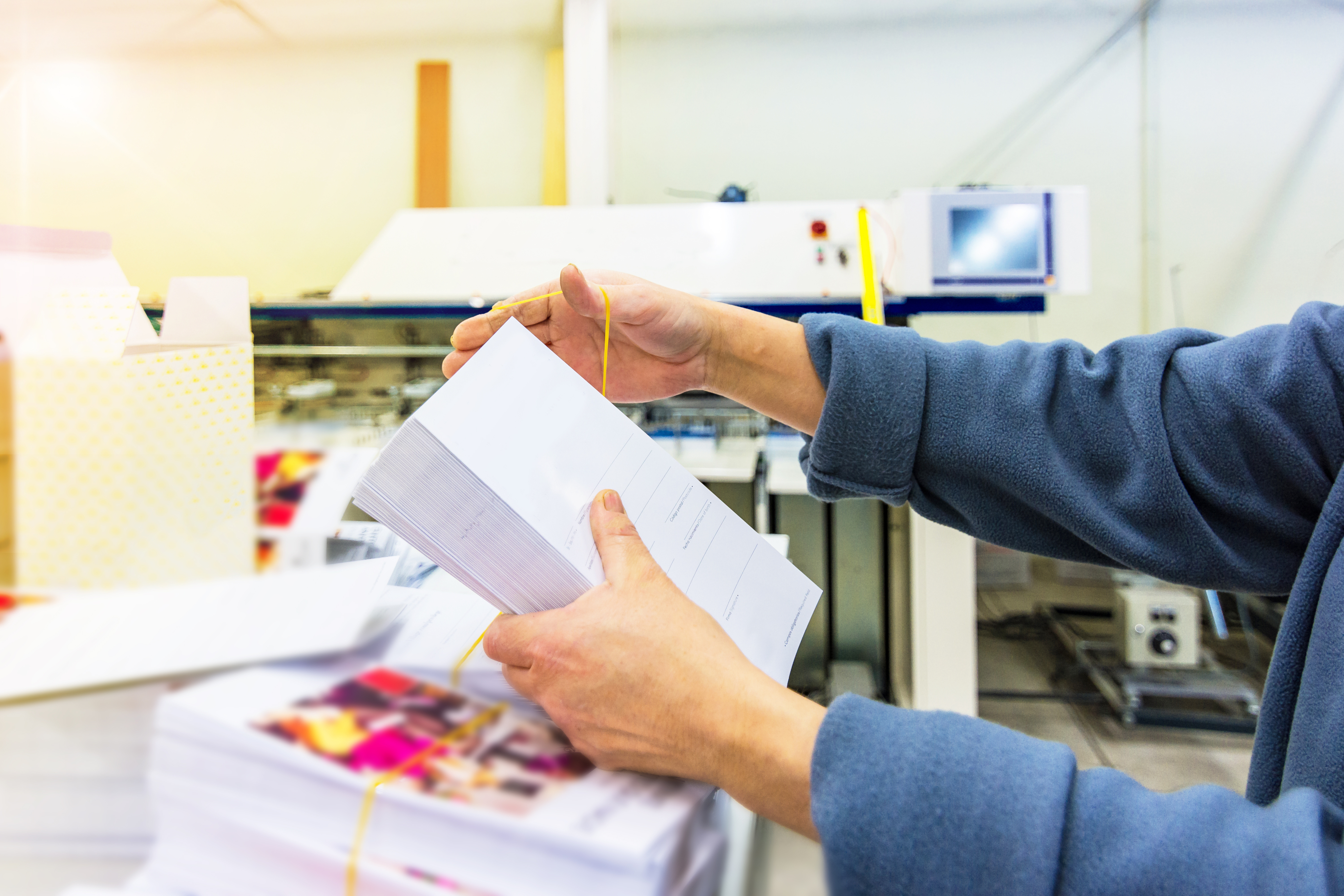 Marketing leader reviewing a direct mail piece at a production facility